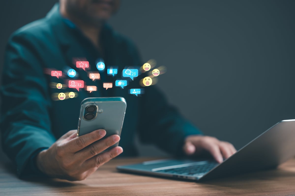 Social media marketing on smartphone and laptop showing engagement analytics